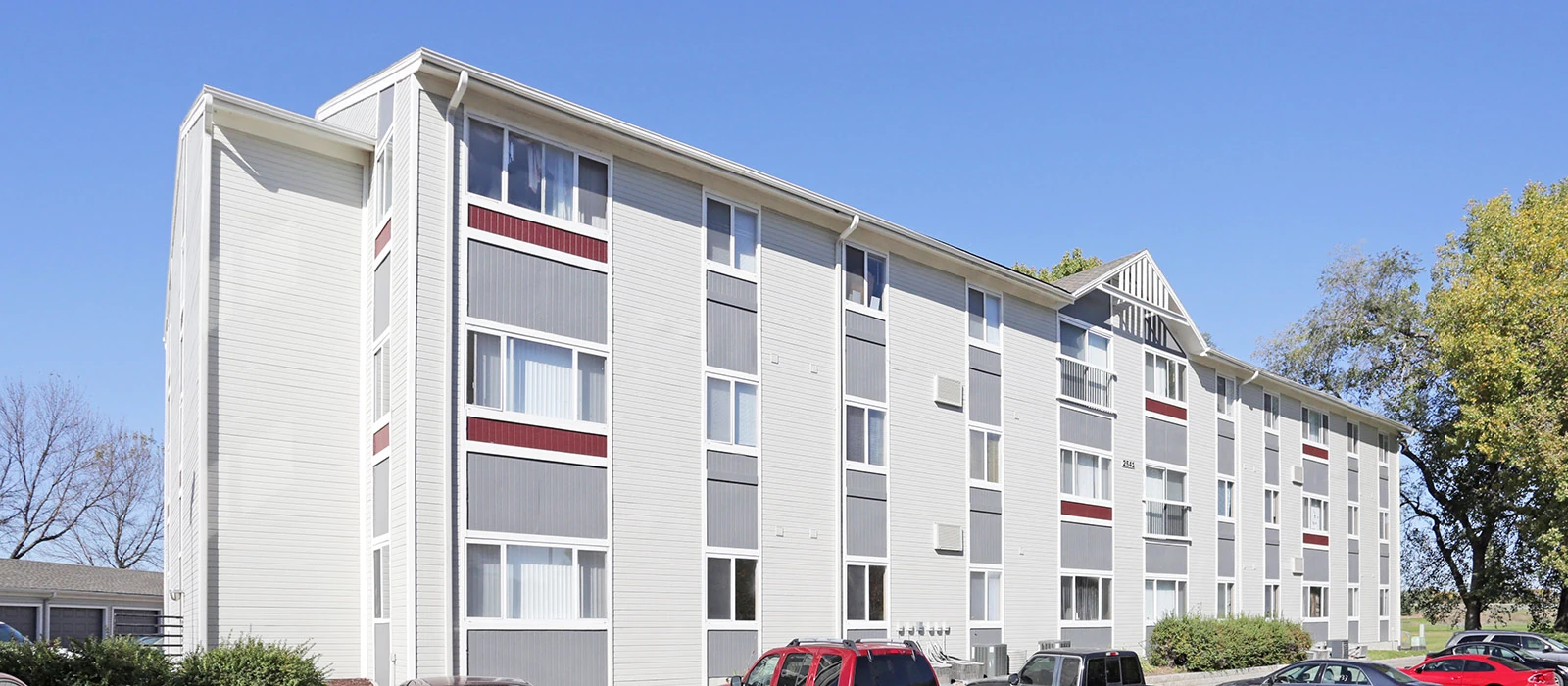 Black leather journal with silver steel disc binding resting on wooden shelf with machined steel pen.